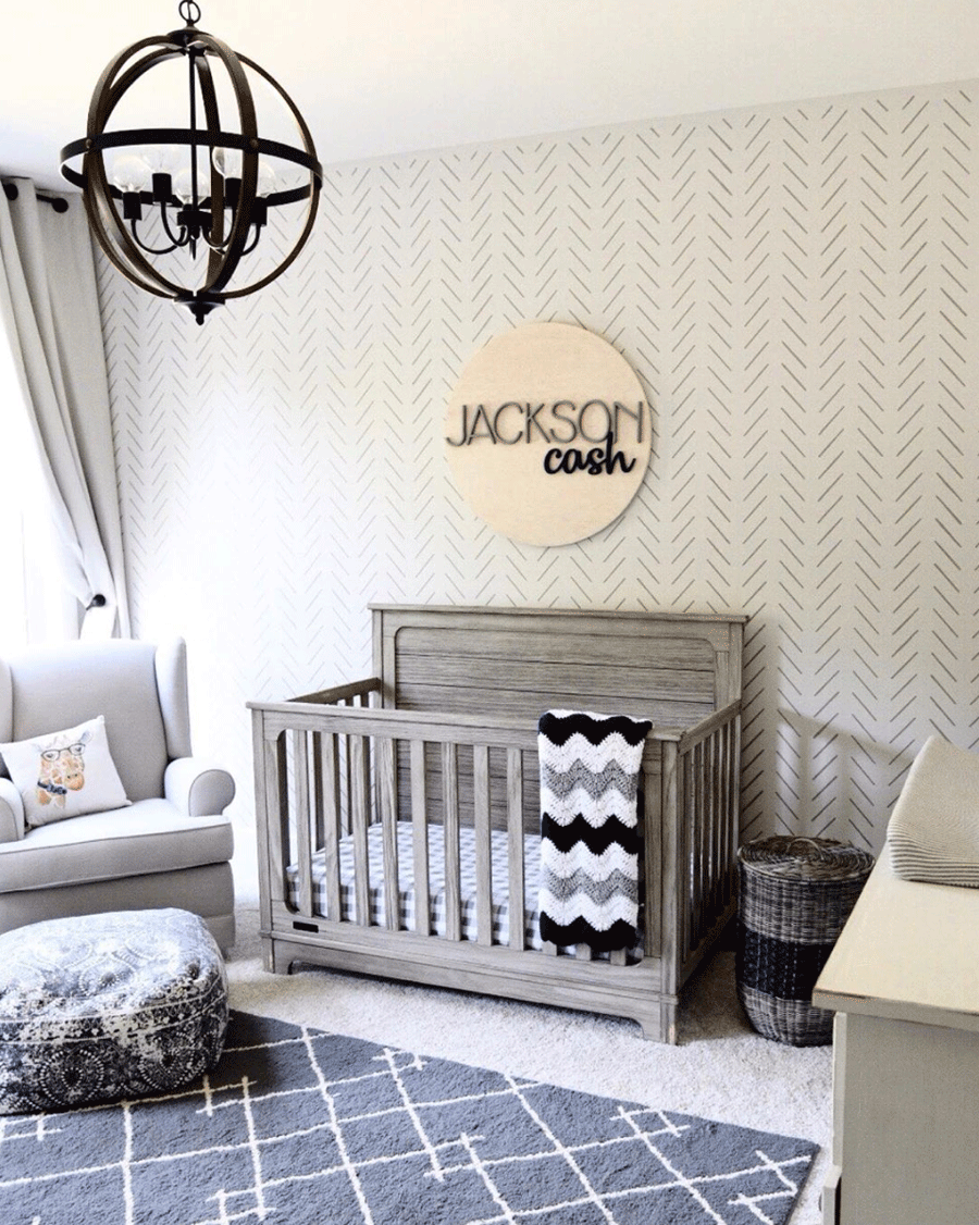 Nursery with stenciled art on the wall.