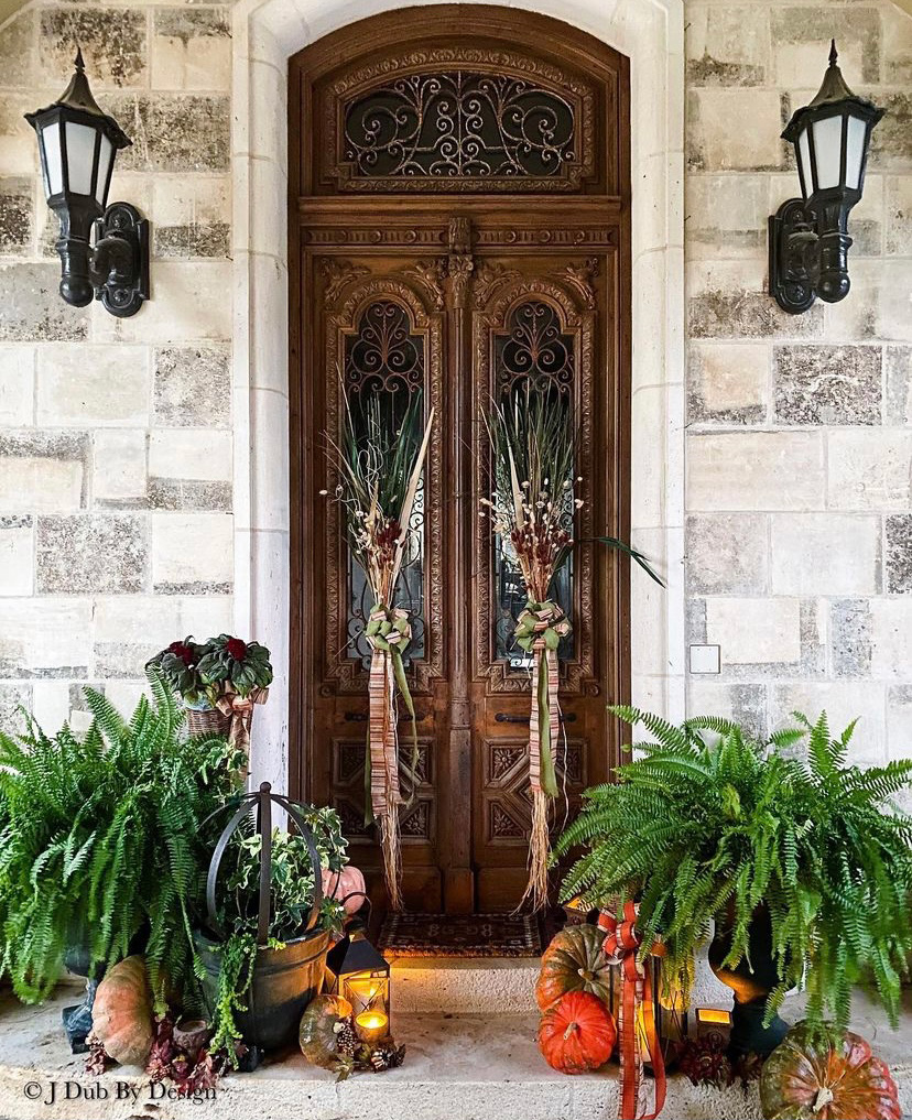 wooden double doors on the front of a home with fall accents