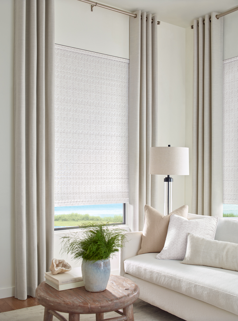 neutral living room with floor to ceiling drapery and fabric shades