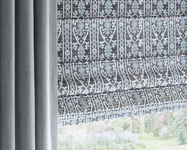 plush blue drapes framing blue and gray and white patterned roman shades