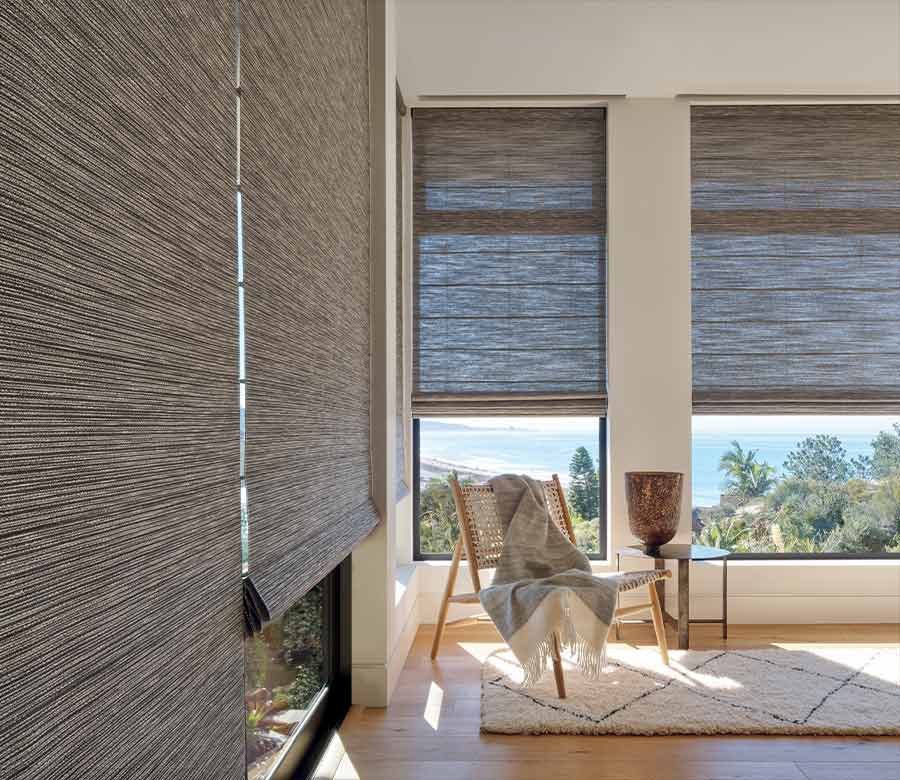 Woven shades on large windows in vacation home overlooking the outdoors