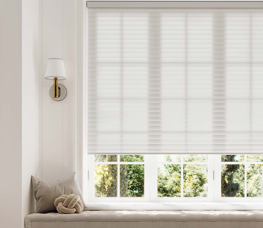 sonnette-shades-window-seat-light-gray-white-hinged-grid-windows-at-home-blinds-and-decor Light-filtering white cellular window shade above a built-in window seat in a bright living room