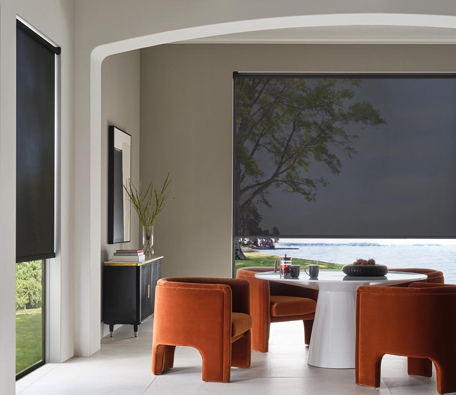 black screen shades in dining room with orange chairs